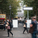 Busy urban walkway with blurred pedestrians and blank signs