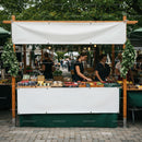 Vendors arranging fresh goods at outdoor market stall