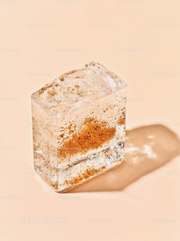 Close up of textured ice cube with embedded particles