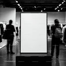 Blank vertical frame in modern clothing store interior