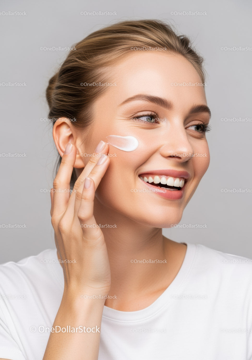 Young woman applying facial moisturizer with a bright smile
