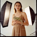Young woman holding a chameleon in soft studio light