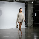 Young woman walking in oversized knitted sweater indoors