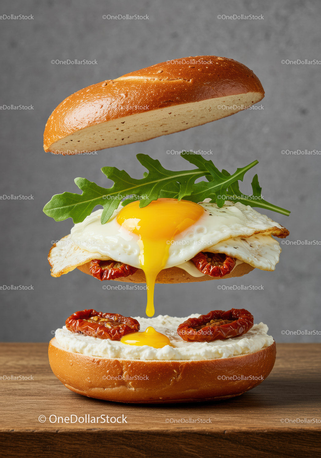 Open bagel sandwich with fried egg and sun dried tomatoes