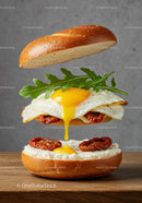 Open bagel sandwich with fried egg and sun dried tomatoes
