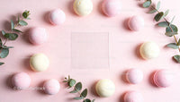 Pastel Macarons and Eucalyptus Branches on Pink Background
