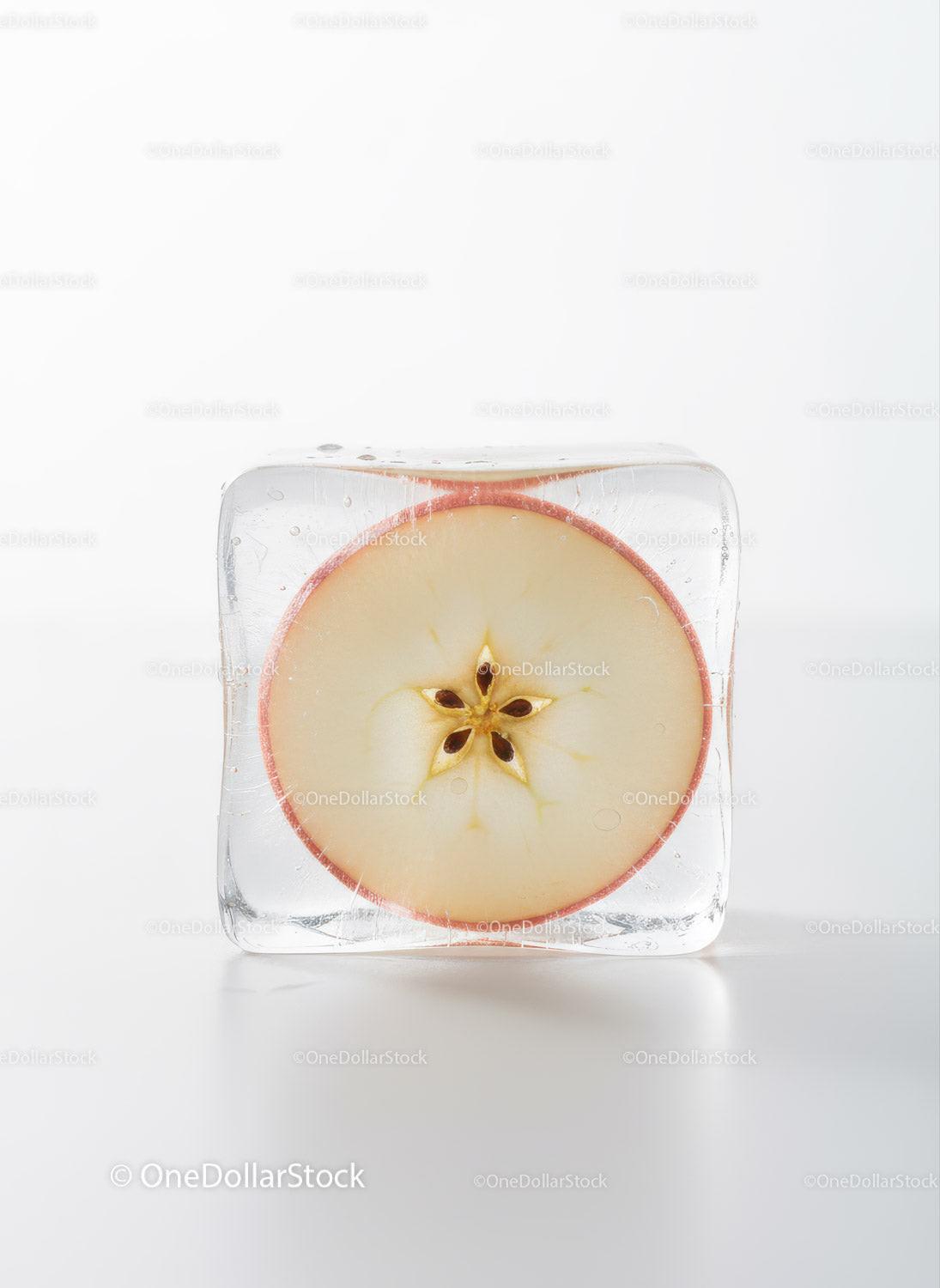 Fresh apple slice frozen inside clear ice cube