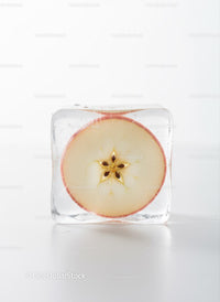 Fresh apple slice frozen inside clear ice cube