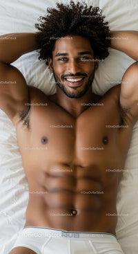 Smiling muscular man relaxing on bed in white underwear