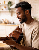 Man enjoying playing acoustic guitar at home