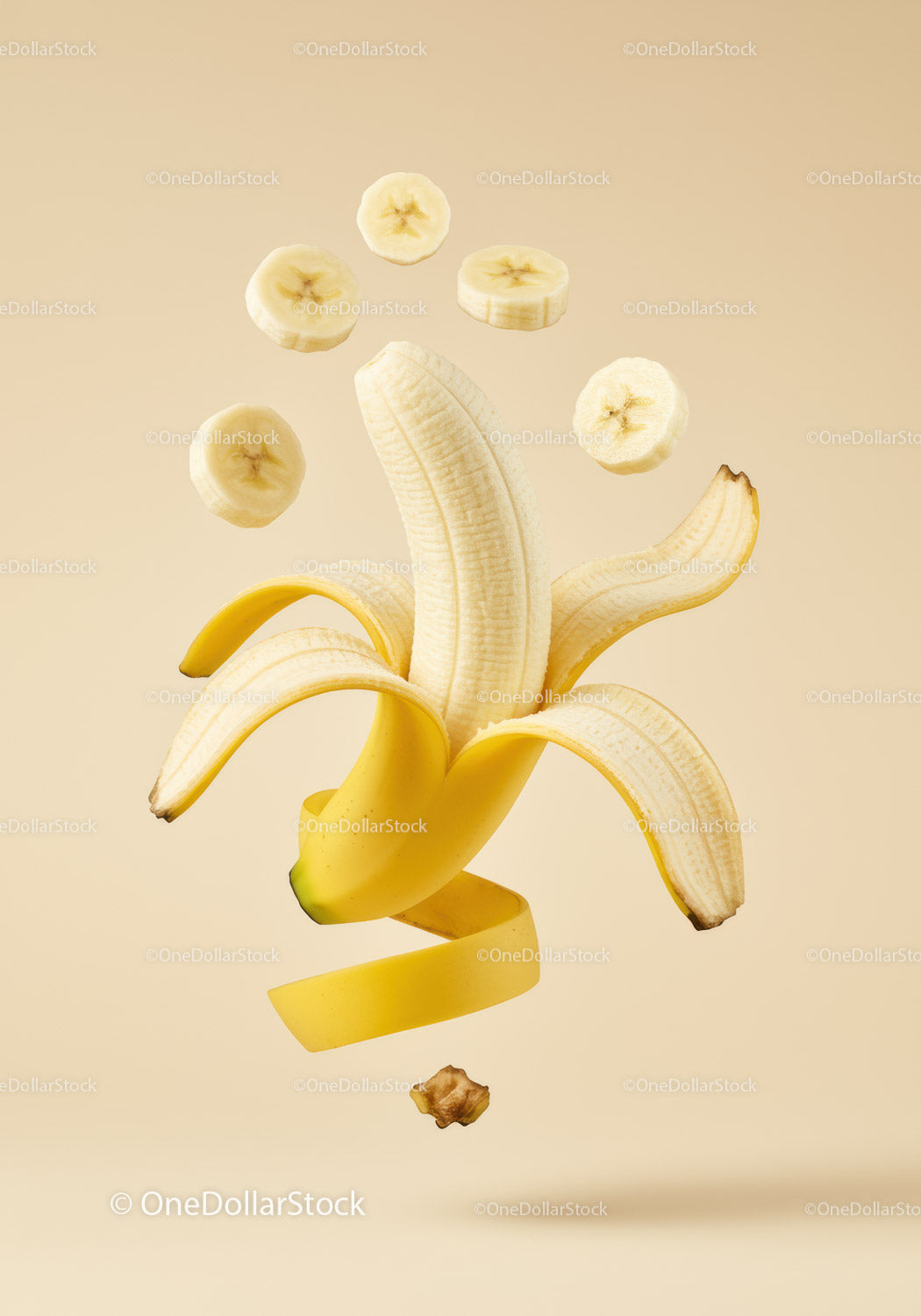 Peeled banana with floating sliced pieces on beige background