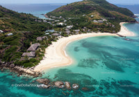 Tropical Beach with White Sand and Turquoise Waters Surrounded by Green Hills