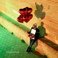 Man Holding Heart Balloons and Chocolates Outdoors