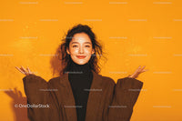 Fashionable Woman Smiling with Confetti on Yellow Background