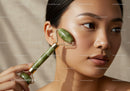 Young Woman Using Jade Roller for Facial Skincare and Relaxation
