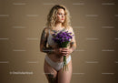 Young Woman with Tattoos Holding Purple Flowers in White Lingerie