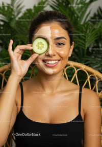 Woman with Facial Mask and Cucumber Slice in Spa Setting