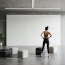 Woman standing in modern minimalist room with poufs