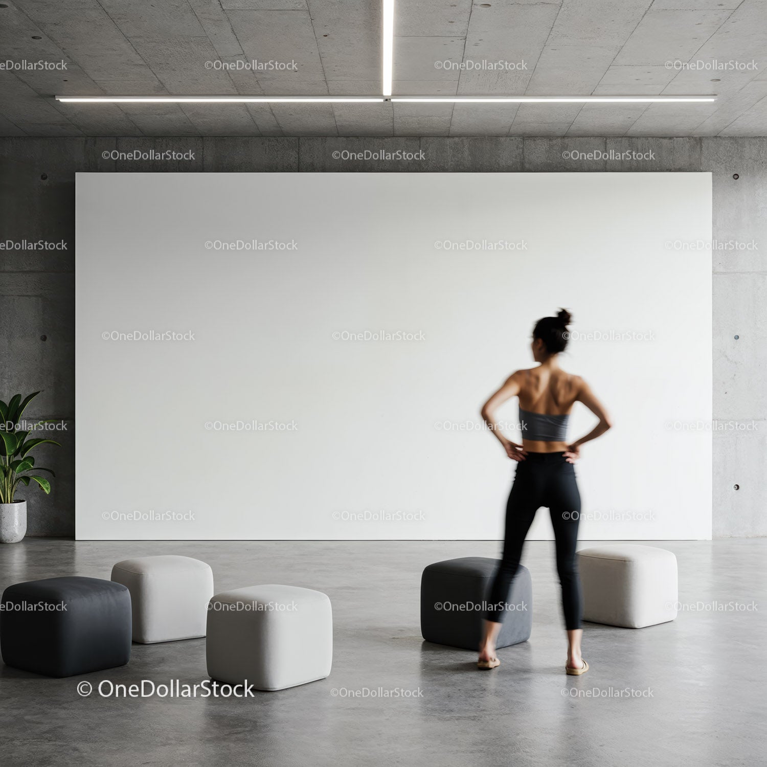 Woman standing in modern minimalist room with poufs