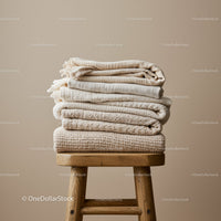 Stack of Soft Neutral Colored Blankets on Wooden Stool