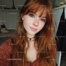 Portrait of a Red-Haired Woman with Blue Eyes and Freckles in Indoor Setting