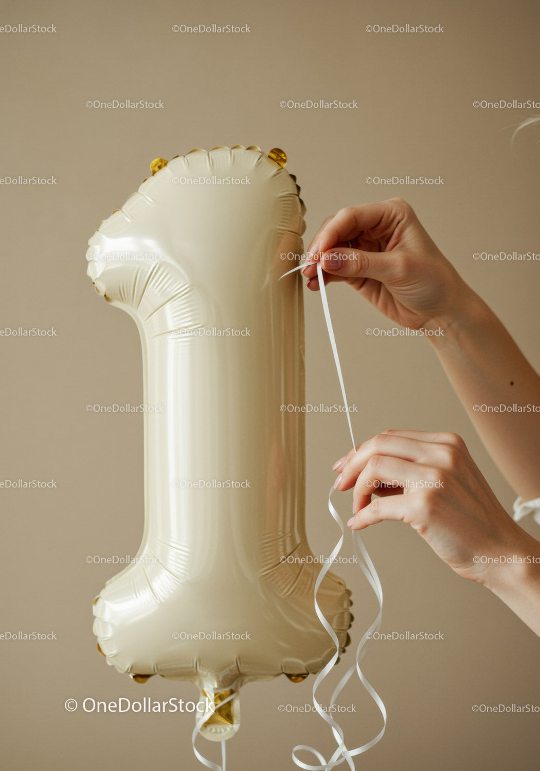 Hands tying white ribbon on number one balloon