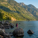 Mountain Lake Scene with Rocky Shore and Hiker in Nature