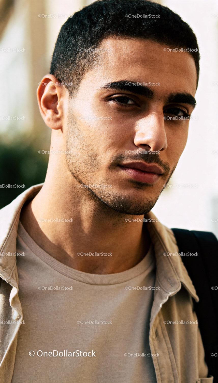 Thoughtful young man with calm expression outdoors