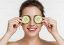 Young Woman Holding Cucumber Slices Over Eyes for Refreshing Skincare