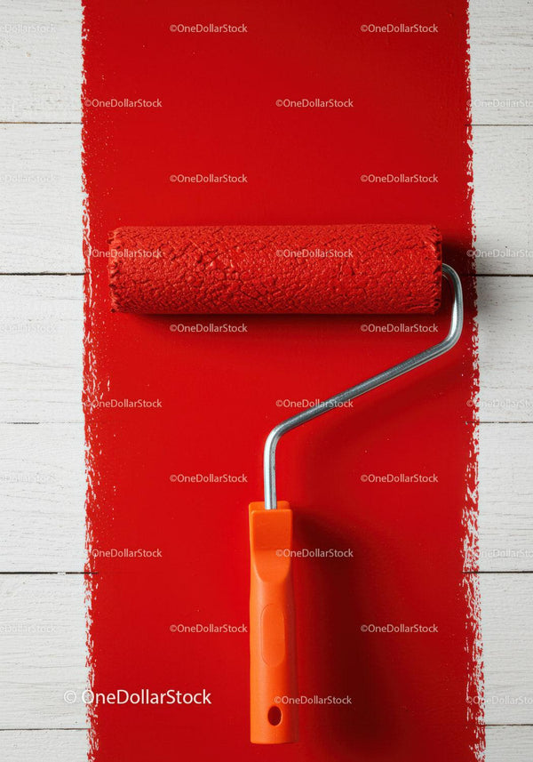 Red Wall Being Painted with Paint Roller for Home Renovation