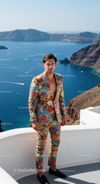 Man in vibrant floral suit overlooking sea cliffs