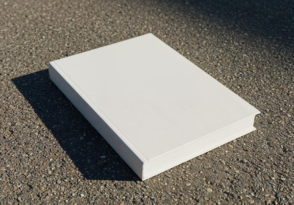 Blank white book on rough outdoor pavement surface JPG Mockup Image