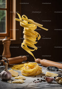 Fresh pasta flying over rustic kitchen counter