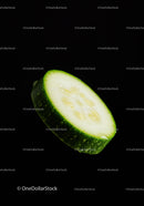 Fresh cucumber slice with water droplets on black