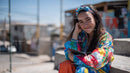 Young Woman Smiling with Smartphone in Urban Street Scene