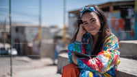 Young Woman Smiling with Smartphone in Urban Street Scene