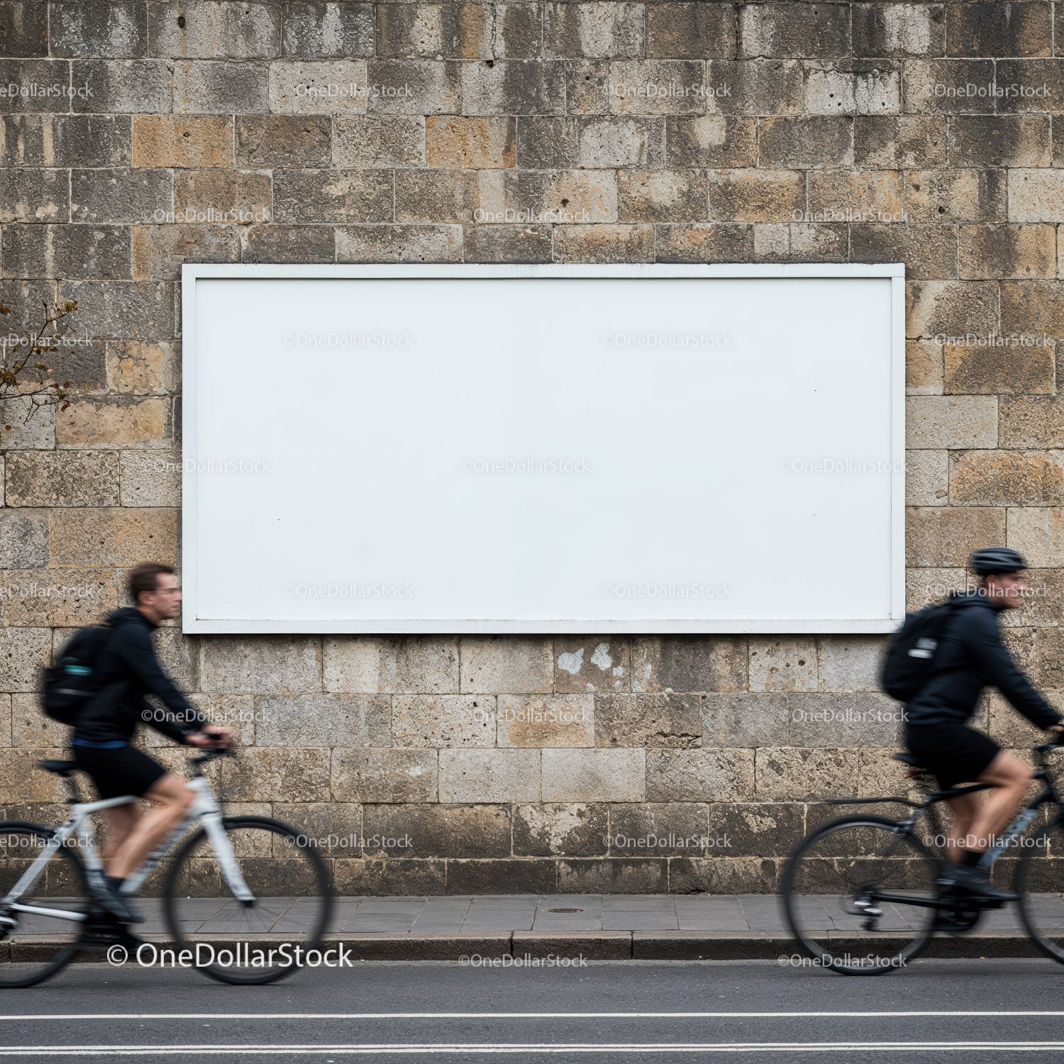 Two cyclists passing blank billboard on stone wall