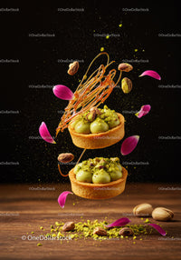 Pistachio tarts with caramel and flower petals in motion