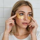 Young Woman Applying Gold Eye Patches for Skincare Treatment