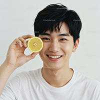 Smiling Young Man Holding Slice of Lemon in Bright Portrait
