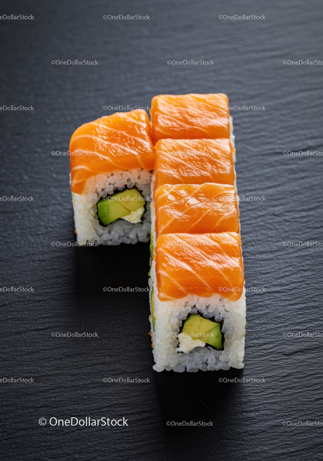 Świeże rolki sushi z łososiem i awokado na czarnym łupku