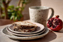 Rustic Breakfast Scene with Sliced Bread and Pomegranate in Ceramic Tableware