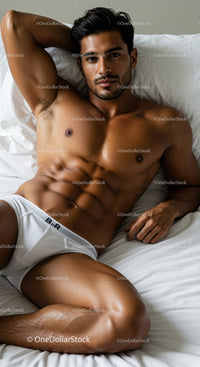 Fit man relaxing on white bed in casual underwear