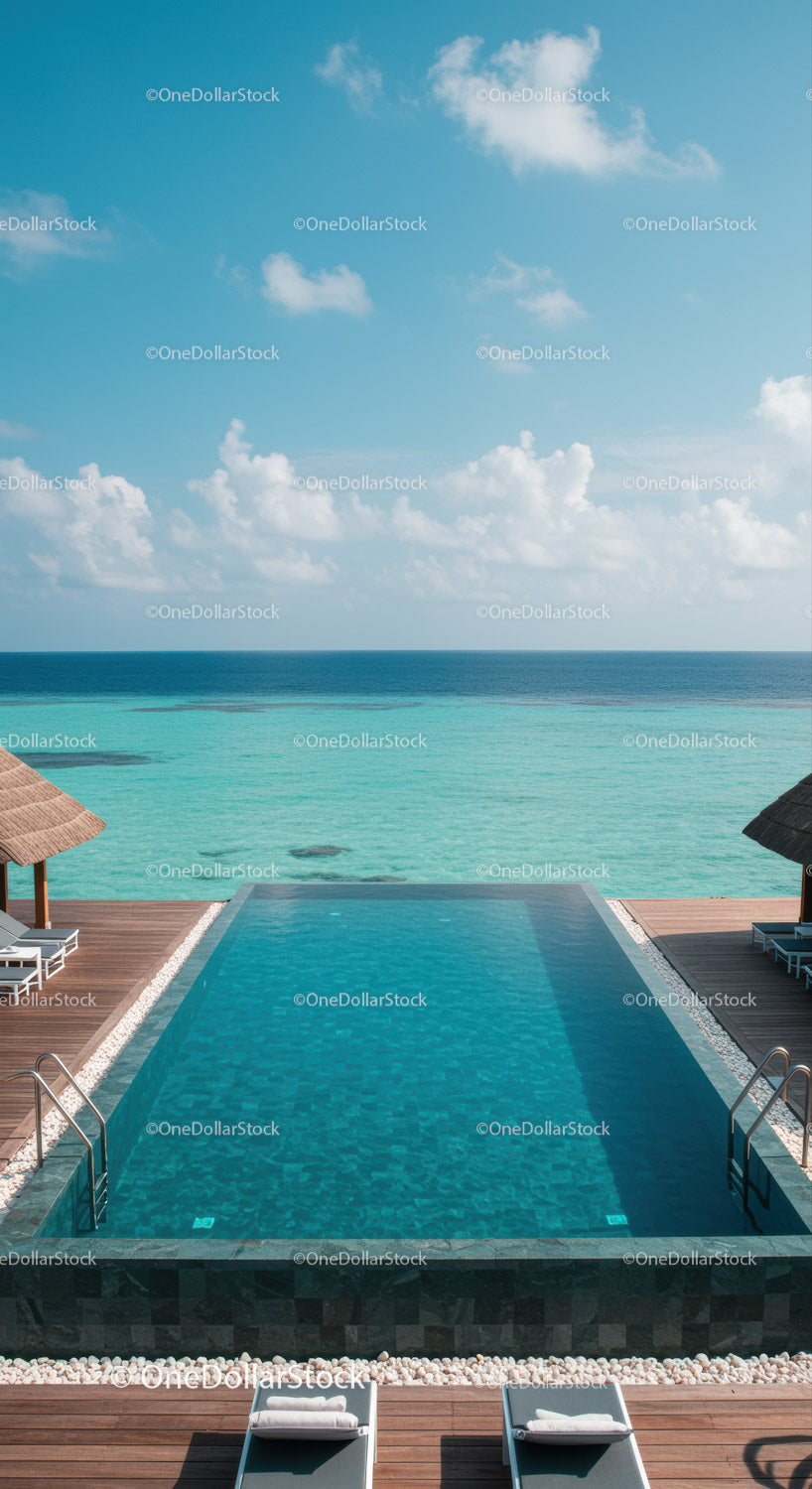 Luxury Infinity Pool Overlooking Calm Ocean with Wooden Deck and Loungers