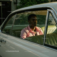 Young Man in Pink Shirt Sitting in Vintage Car on a Sunny Day