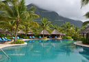 Tropical Paradise with Swimming Pool and Palm Trees Over Mountain Landscape