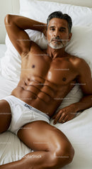 Fit mature man relaxing on bed in white briefs