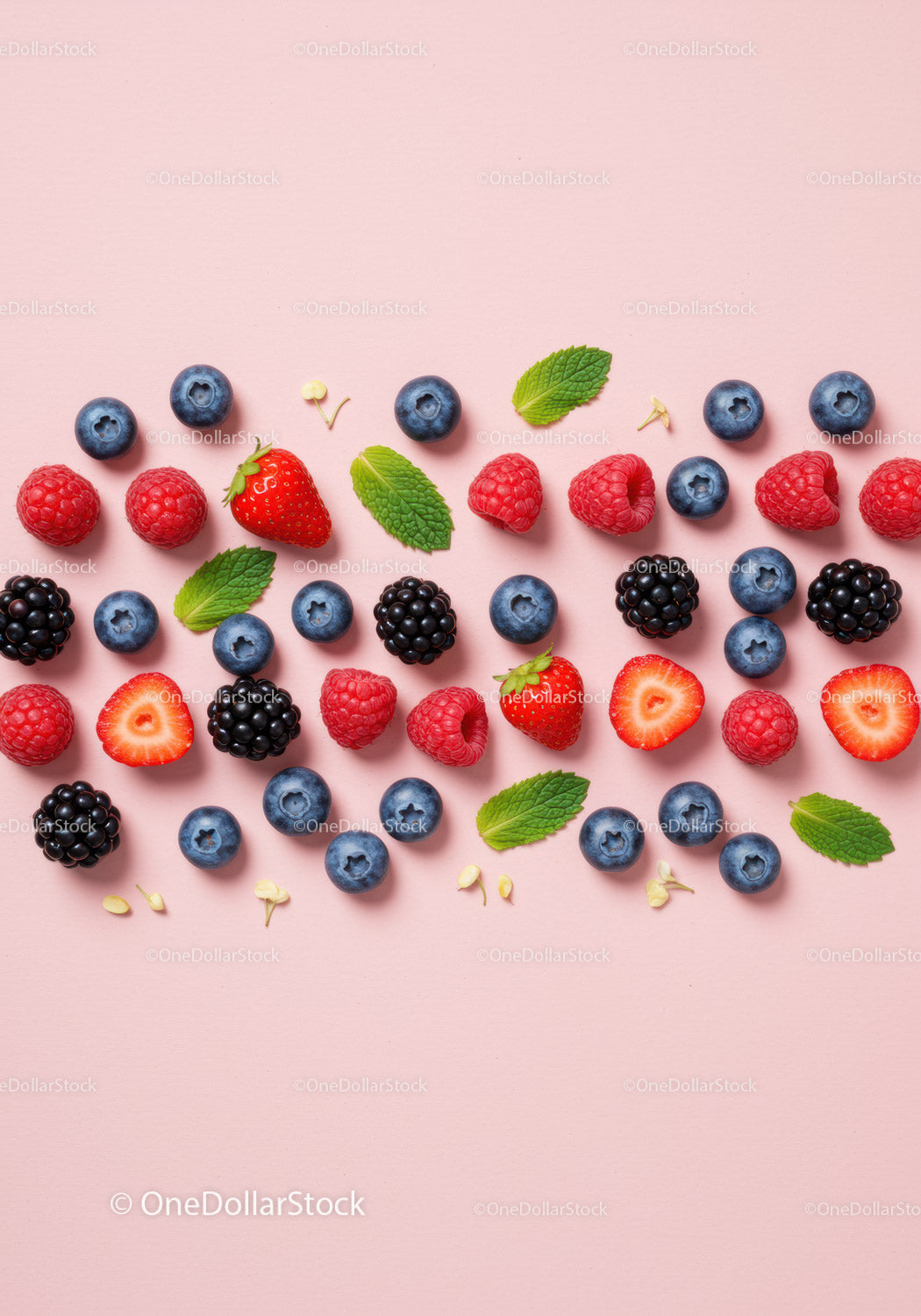 Fresh mixed berries and mint leaves on pink background