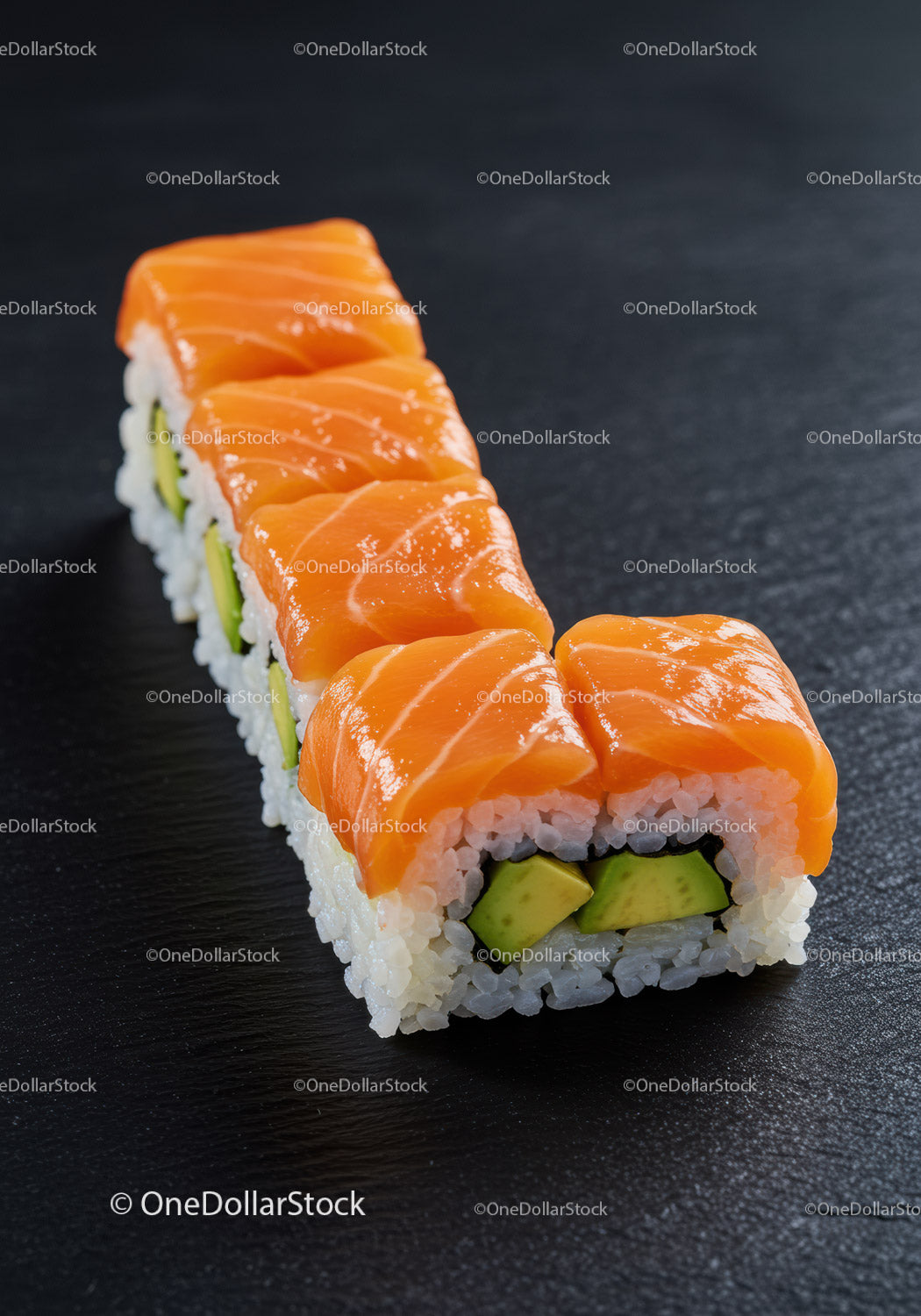Świeże rolki sushi z łososiem i awokado na czarnej powierzchni