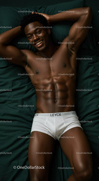 Smiling man relaxing in white underwear on dark bed